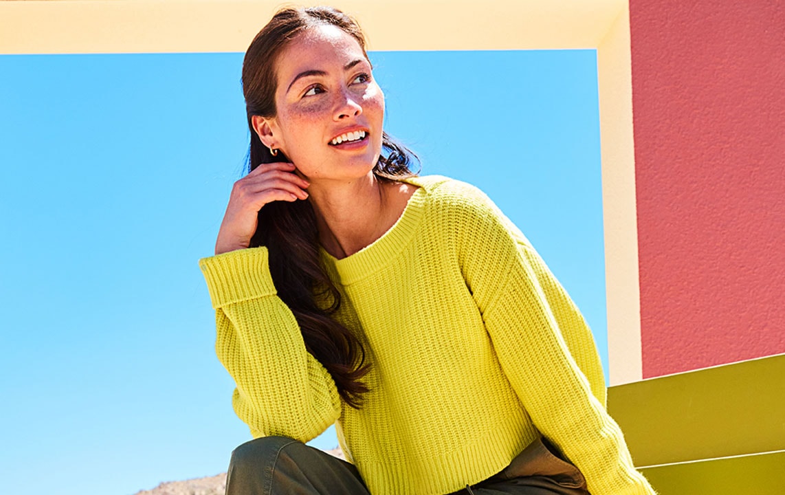 lifestyle image of woman in yellow sweater
